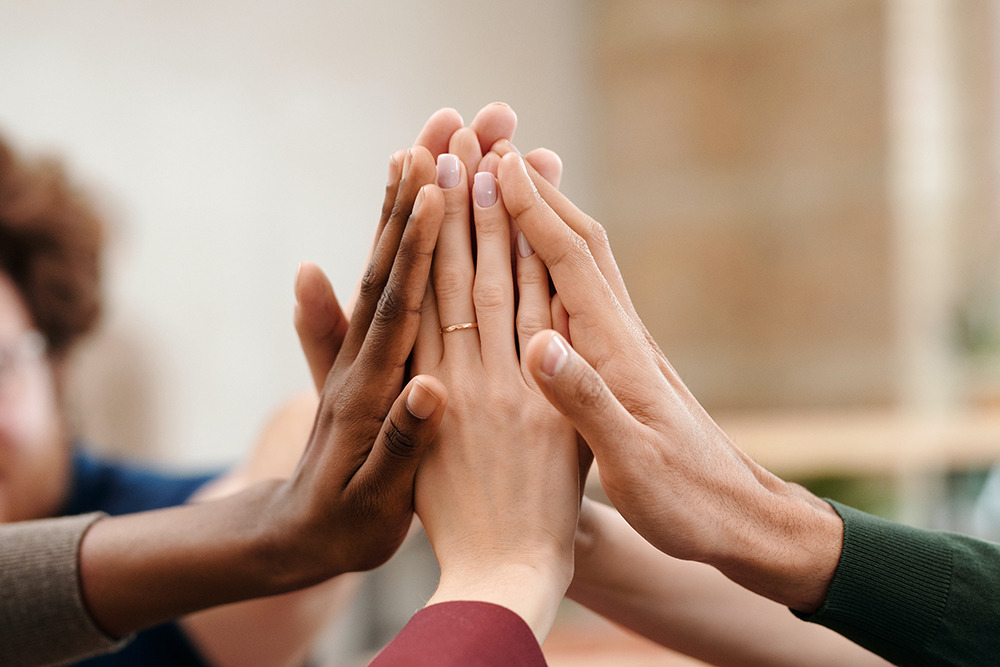 Group of people putting their hands togther